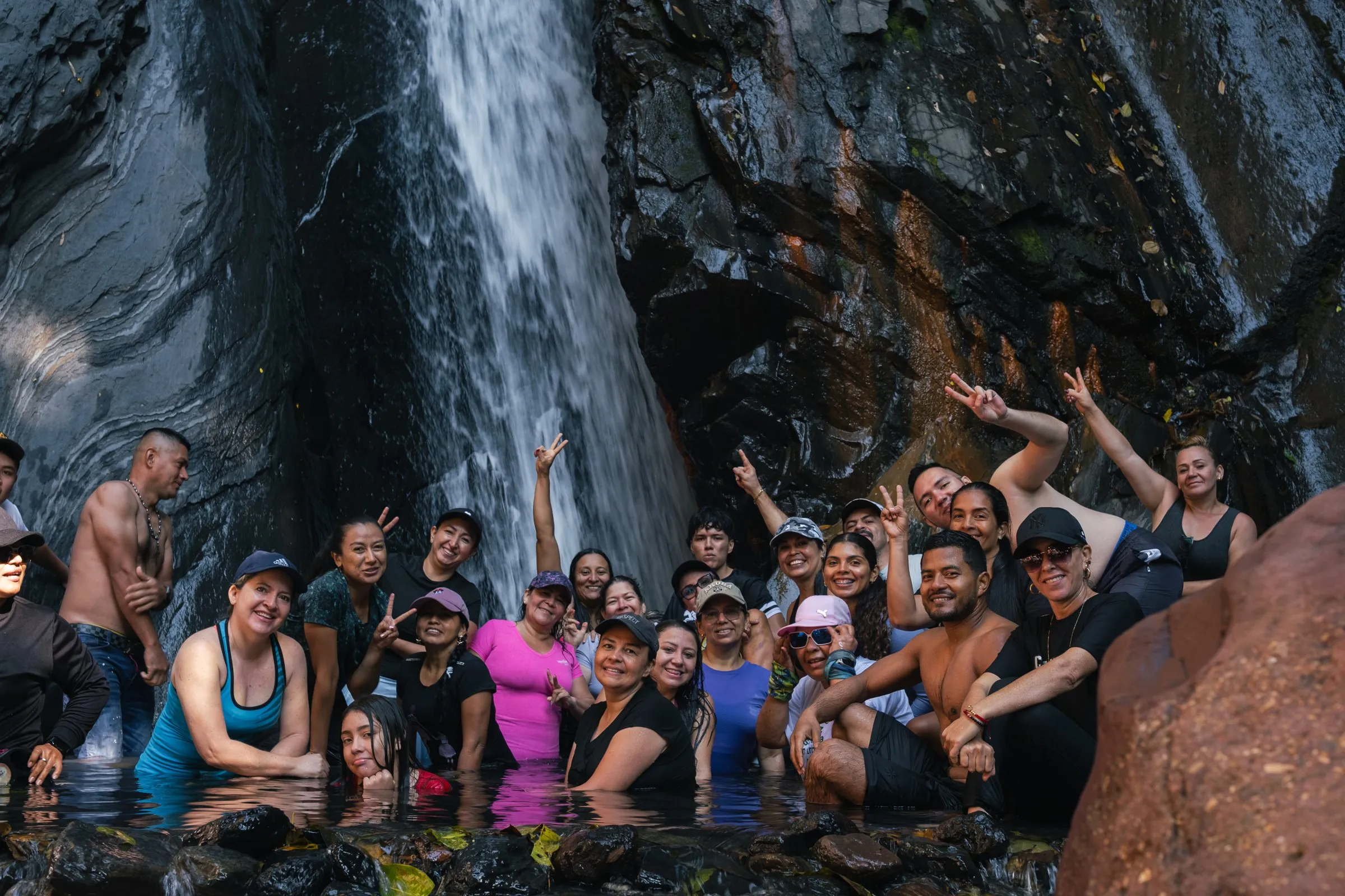 Grupo de personas celebrando bajo una cascada